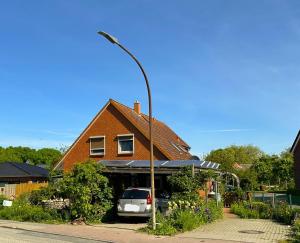 a house with a car parked in front of it at Ferienwohnung-Wildblume in Petersdorf auf Fehmarn