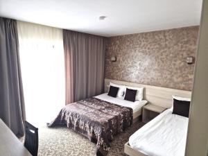 a hotel room with two beds and a window at Sunrise Villa in Baile Felix