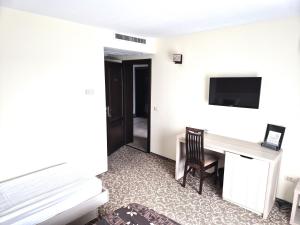 a hotel room with a desk and a television at Sunrise Villa in Baile Felix