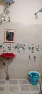 a bathroom with a sink and blue flowers on the wall at Hotel MeghTora in Goālpāra