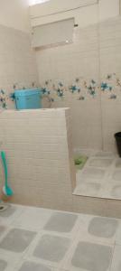 a bathroom with a shower with flowers on the wall at Hotel MeghTora in Goālpāra