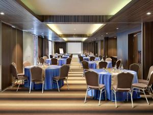 a conference room with tables and chairs and a screen at Mercure Bali Legian in Legian +152 photos