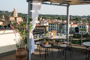 a balcony with tables and chairs and a view of a city at Hotel Principe in Florence