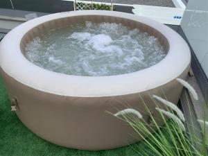 a bath tub filled with water sitting on top of grass at VILLA HELENA Crystal Apartment in Caniço