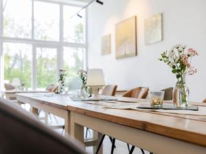 a long wooden table with vases of flowers on it at Heeser Hof - Natururlaub direkt am Nationalpark Maasduinen - Natur & Rad & Wanderwege ab Hof - Auszeit auf dem Land - Hunde willkommen in Weeze