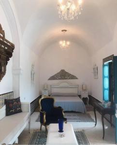 a bedroom with a bed and a couch and a table at Darelkhir in Tazarka
