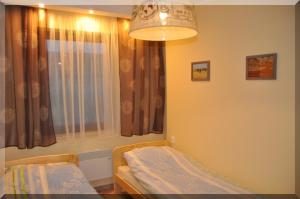 a bedroom with a bed and a window with curtains at W Cieniu Akacji in Jaworki