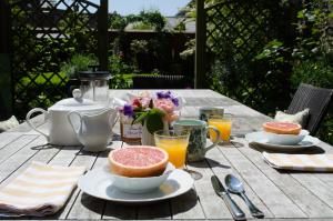 a picnic table with a breakfast of fruit and orange juice at The Hollies Bed and Breakfast in Uppingham