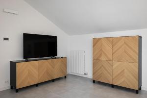 a tv and a wooden cabinet in a room at Antares b&b in Cassina deʼ Pecchi