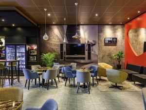 a restaurant with tables and chairs and a tv at Ibis Berlin Hauptbahnhof in Berlin