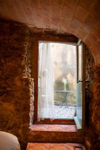 a window in a stone room with a table outside at Can Gandaia in Viladamat