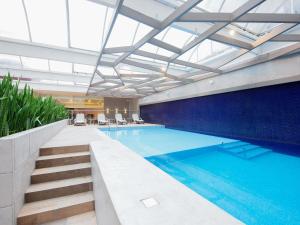 a swimming pool in a building with a ceiling at Mercure Curitiba Batel in Curitiba
