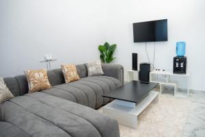 a living room with a gray couch and a table at Malindi White in Malindi
