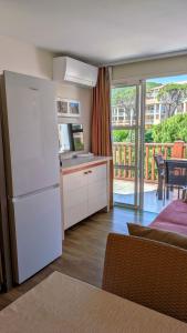 a kitchen with a white refrigerator and a balcony at Studio cabine climatisé vue golf à Cap Estérel in Saint-Raphaël
