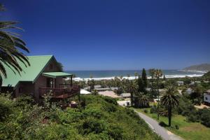 a house on a hill next to the beach at The Loerie's View in Wilderness