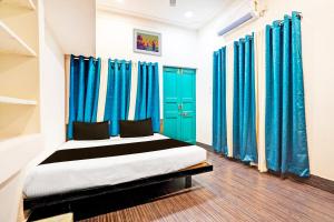 a bedroom with blue curtains and a bed in a room at Super Hotel O THE VANTAGE INN in Nagpur