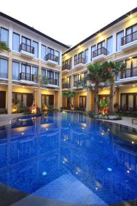 une grande piscine en face d'un bâtiment dans l'établissement Suris Boutique Hotel, à Kuta