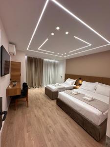 a hotel room with two beds and a desk at Vila Zhiti in Durrës