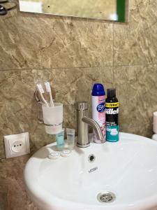 a bathroom sink with toothbrushes and toothpaste on it at MaVi House in Kutaisi +19 photos
