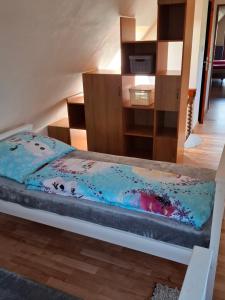 a bedroom with a bed with a blue comforter at Chalupa u Záhradníkov in Trebostovo