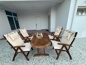 a dining room with a table and four chairs at Skyfall with a large balcony and FREE parking in Central Kiato in Kiaton