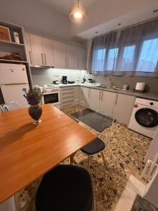 a kitchen with a wooden table and chairs in it at Skyfall with a large balcony and FREE parking in Central Kiato in Kiaton