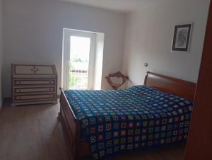 a bedroom with a bed and a dresser with a window at Appartamento vacanza Penne in Penne