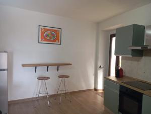 a kitchen with two stools in the corner of a room at Appartamento vacanza Penne in Penne +7 photos
