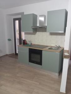 a kitchen with white cabinets and a stove top oven at Appartamento vacanza Penne in Penne