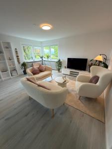 a living room with two chairs and a television at Sweet Home in Aarhus