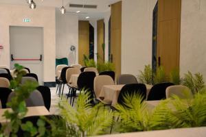 a row of tables and chairs in a room with plants at Nayel Hotel in Durrës