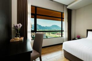 a hotel room with a bed and a large window at Amari Vang Vieng in Vang Vieng
