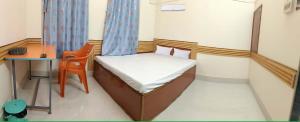 a small room with a small bed and a desk at Hotel MeghTora in Goālpāra