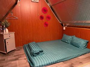 a bed in a room with a wooden wall at Homestay Vườn Cam in Kon Von Kla