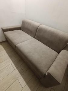 a brown couch sitting in a room at Arcadia Hosting Piazza XX Settembre in Bologna