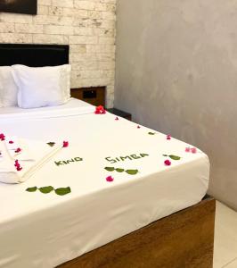 a bed with some flowers on the sheets at King Simba Apartment Hotel & Restaurant in Bwejuu +86 photos
