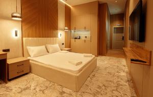 a bedroom with a large bed and a television at EUROPA Hotel in Semey