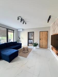 a living room with a blue couch and a table at Luxury Apartments Musialika 18 in Bytom
