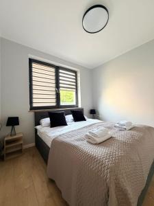 a bedroom with a large bed with two towels on it at Luxury Apartments Musialika 18 in Bytom