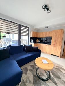 a living room with a blue couch and a table at Luxury Apartments Musialika 18 in Bytom