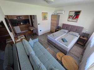 a large bedroom with a bed and a couch at Self Check-in Studio apartman Vito in Lipovac