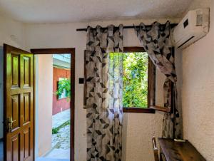 a room with a window with a curtain and a door at Madalenas B&B in Pelekas