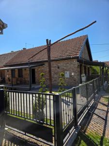 a house with a balcony with a fence at Self Check-in Studio apartman Vito in Lipovac