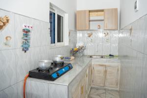 a kitchen with a stove with two pots on it at Malindi White in Malindi