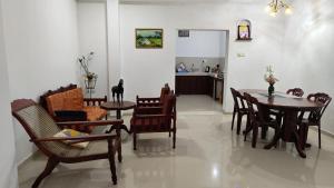 a living room with a dining room table and chairs at Jayasiri Riverfront Home in Lansiyawatta