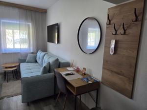 a living room with a blue couch and a mirror at Self Check-in Studio apartman Vito in Lipovac +3 photos