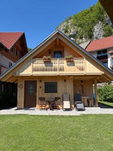 a house with a deck with two chairs and a table at Princess Mojca Holiday House in Bled