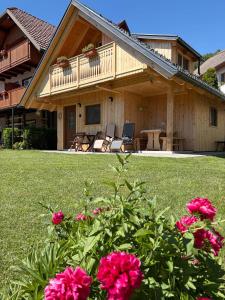 a house with a deck and some pink flowers at Princess Mojca Holiday House in Bled