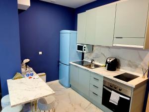 a kitchen with blue walls and a blue refrigerator at Chinatown Luxury Apartment in Madrid