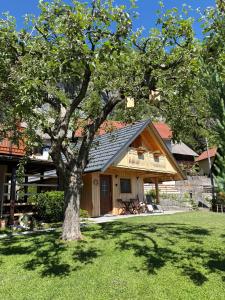 a house with a tree in the yard at Princess Mojca Holiday House in Bled